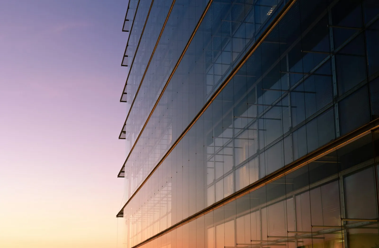 Glass office building reflecting a dusk sky